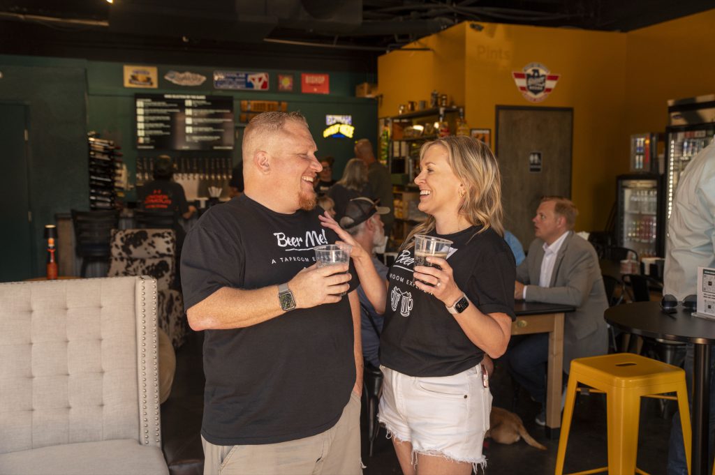 Friends laughing together over drinks at Beer Me! taproom