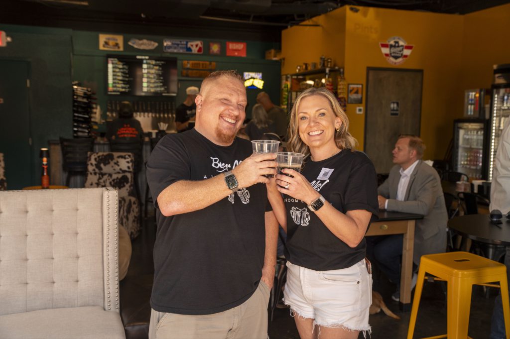 Two friends toasting glasses at Beer Me! taproom