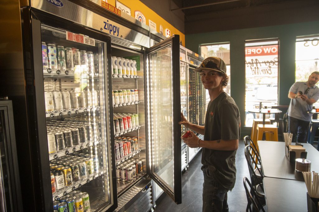A guest pulling a cold can from the packaged to-go coolers at Beer Me!