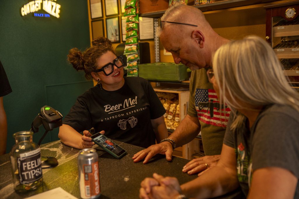 A bartender ringing up guests at the Beer Me! register