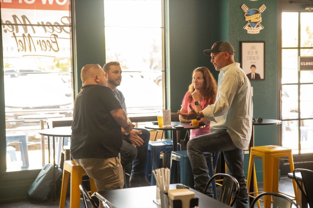 Groups gathered at tables by the windows at Beer Me! taproom